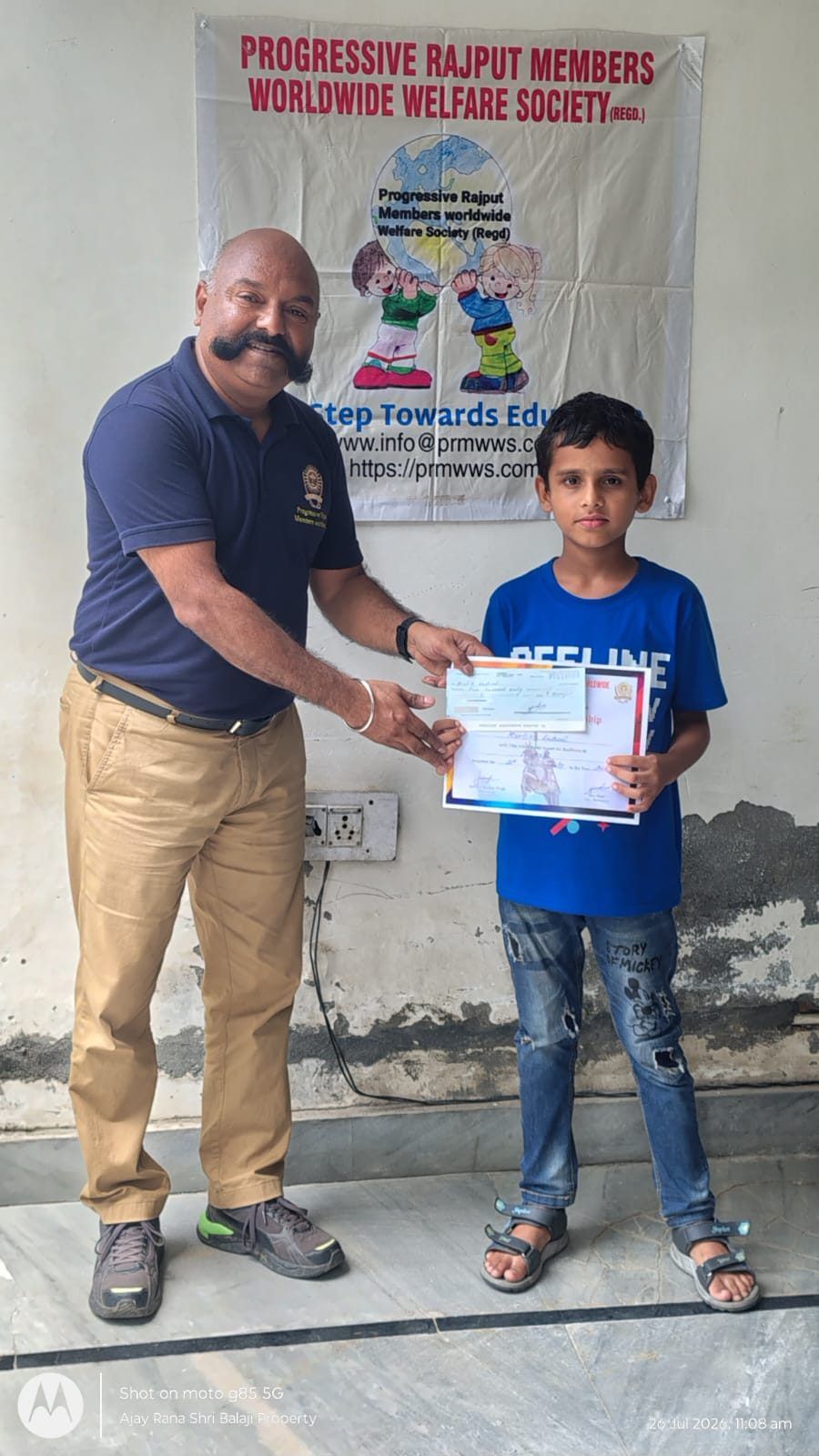 A student receiving his scholarship certificate
